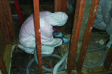remediation technician working in a containment barrier